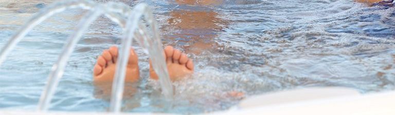 Ulkoporealtaassa näkyvät varpaat, jotka ovat vesipuotouksen poreissa.